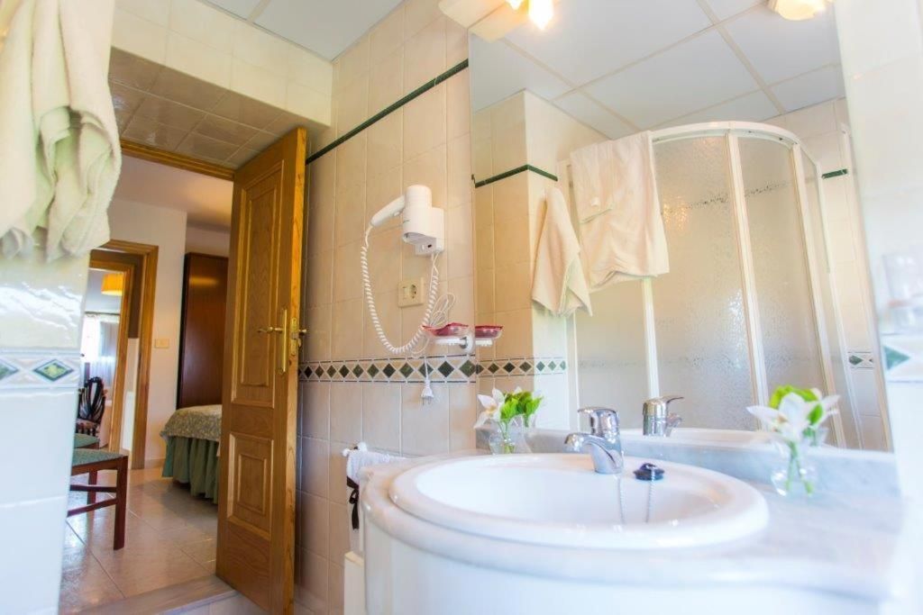 Un baño con un lavamanos grande, una ducha y un espejo.