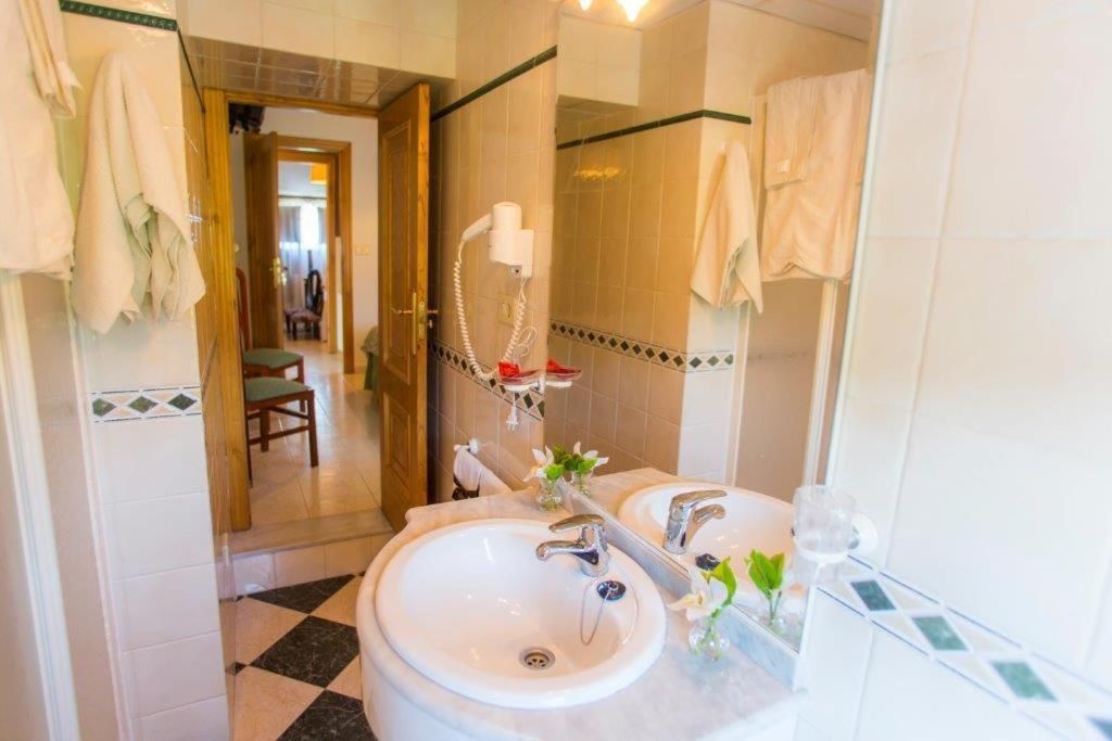 Une salle de bain avec deux lavabos, un sèche-cheveux et un miroir.