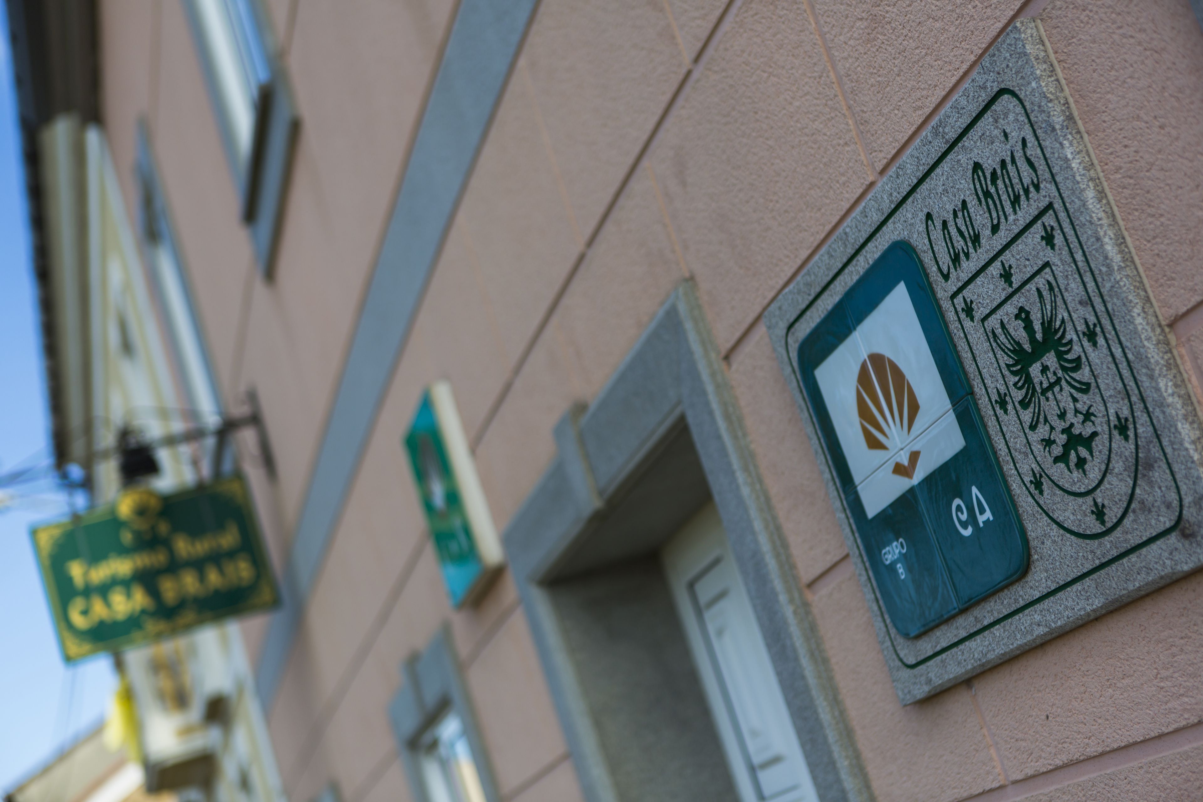En bygnings facade med et skilt der siger "Casa Brasil" og et logo med en fugl og et skjold.