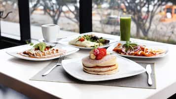 Une table avec différents plats, un verre de jus vert et une tasse blanche.