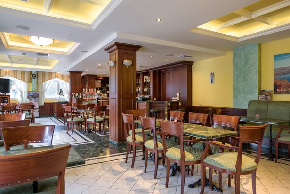 Un restaurante con mobiliario de madera, una zona de bar y vistas a la ciudad.