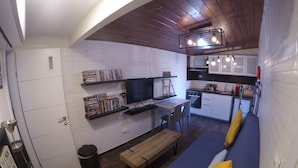 A compact living space with a kitchenette, a dining area, and a sofa with cushions. -  Avis Place -designed two-bedroom penthouse apartment with breathtaking views (תל אביב יפו)