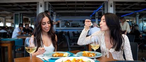 Dos personas cenan en un restaurante con vista al área de la cocina.