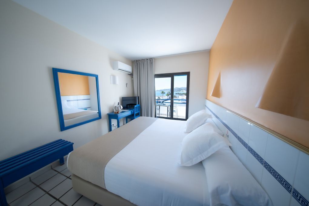 Une chambre d’hôtel comprenant un lit, un bureau, une chaise, une fenêtre avec vue et une salle de bain.