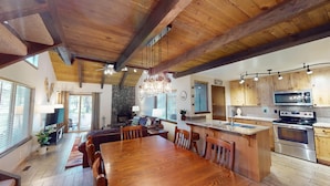A spacious kitchen with wooden cabinets, a large island, and modern appliances. - Spa-Side Lodge with Access to Exclusive Golf (Sunriver)