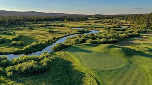 A golf course with water hazards, lush greenery, and distant mountains. - Sunriver Stay with Access to The Cove (Sunriver)