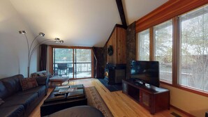 Una sala de estar con chimenea, un sofá, una mesa de centro y un televisor.