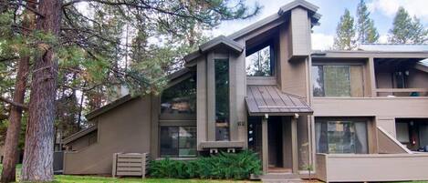 A modern two-story house with a large front porch, a garage, and a well-maintained lawn.