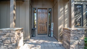 Stately entrance with a welcoming sign and stone pillars.