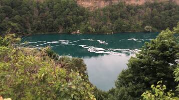 Surrounded by lush greenery and a cliffside, this serene river offers a tranquil setting.