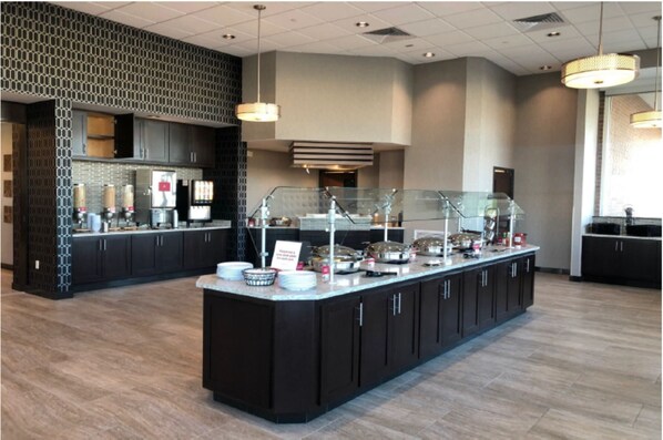 A modern breakfast bar with a glass enclosure, dark cabinetry, and a patterned wall.