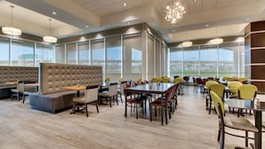 Un comedor espacioso con techos altos, ventanas amplias y luminarias modernas.