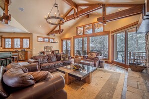 A spacious living room with a large sectional sofa, a glass coffee table, and a fireplace.