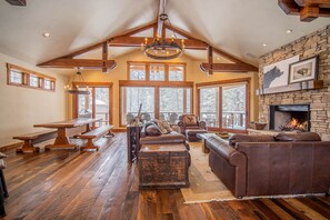 Relax in this inviting living area with a high vaulted ceiling, stone fireplace, and comfortable seating.