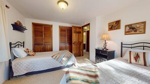 A bedroom with two beds, wooden wardrobes, a desk, and a lamp. - Wrap-Around Deck | Fireplace | Ward Cabin (Angel Fire)