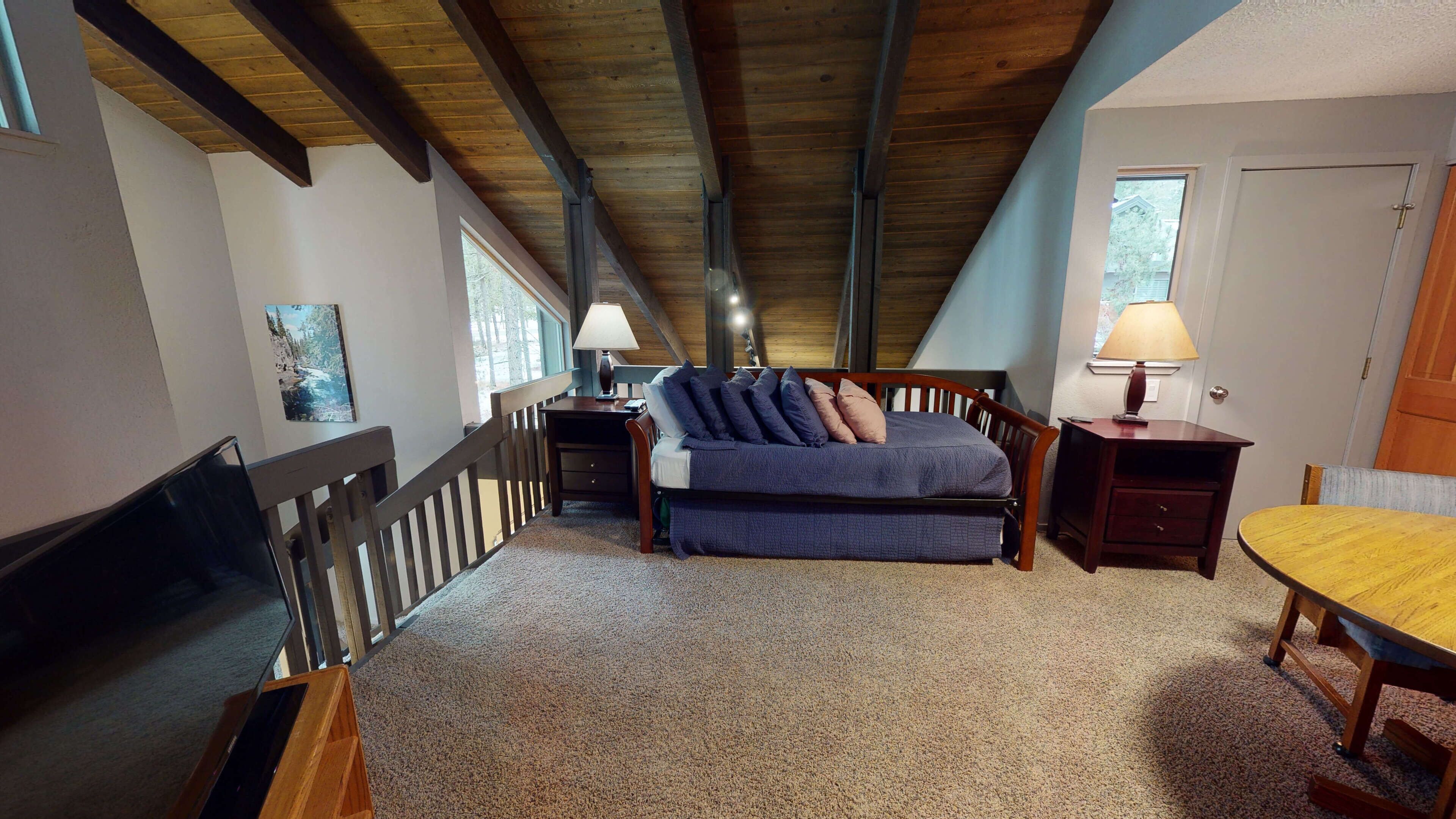 A bedroom with a bed, a desk, a chair, and a window.