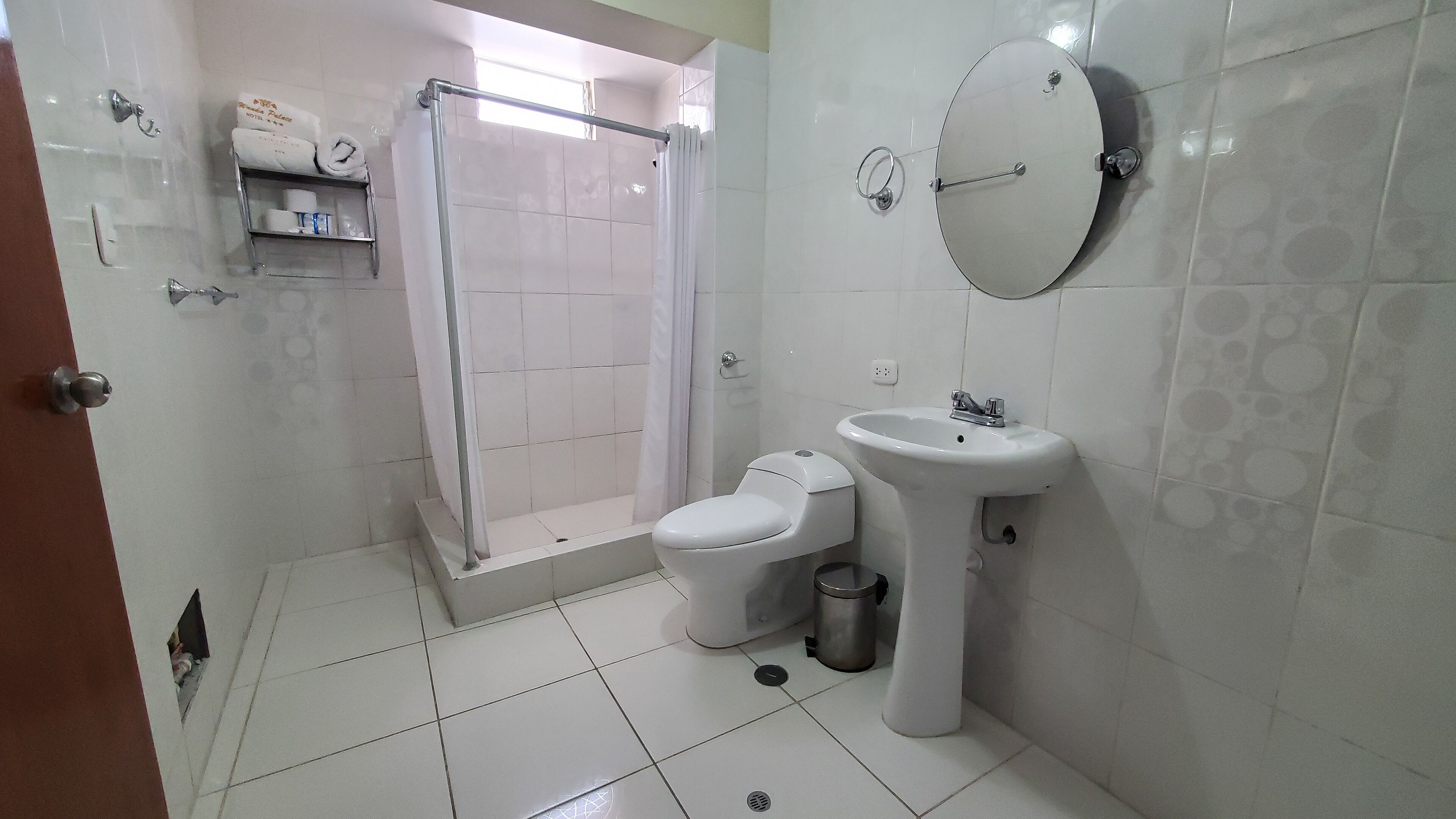 A bathroom with a toilet, sink, and shower.