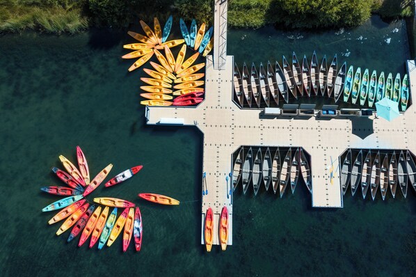 An aerial view of a dock with multiple canoes and kayaks arranged in rows. - Spacious Sunriver Home with Access to The Cove (Sunriver)