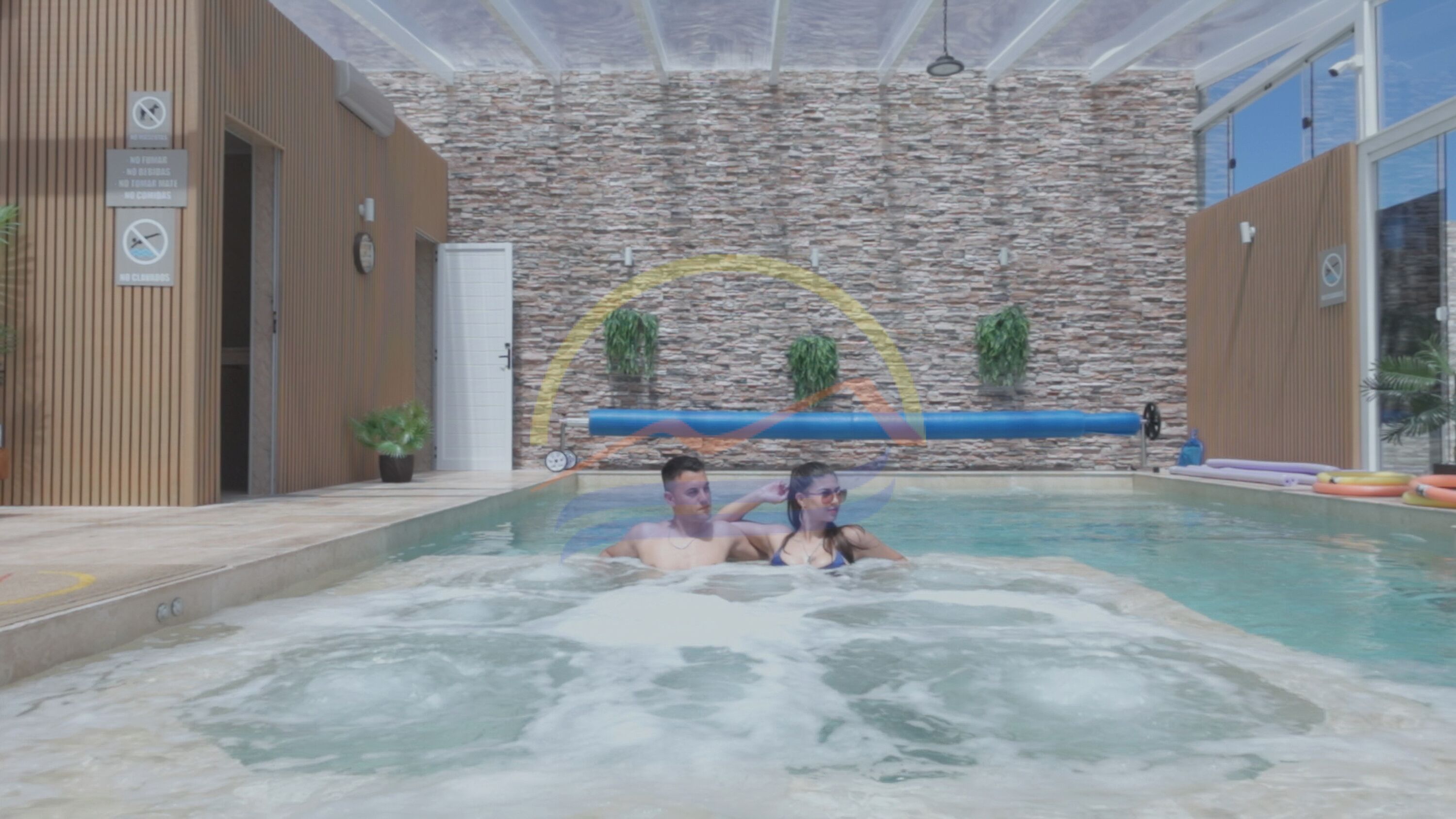 Ein Innenpool mit Steinwänden und Holzverkleidung.