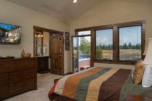 Une chambre à coucher avec un grand lit, une commode en bois et un tableau accroché au mur.