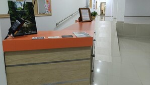 A reception desk with a sign, a mirror, and a plant. - Hotel Empresarial  (Pereira)
