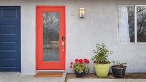 Una casa con una porta rossa, una porta blu e la lettera 'B' sulla parete.