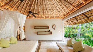 A room with a thatched roof, a bed with a canopy, a sofa, and a wall-mounted shelf. - Unique beach house, luxury experience (Puerto Escondido)