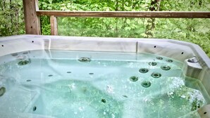 A hot tub with a control panel, surrounded by greenery. - Mountain Oasis Luxurious w/ 5 Star Amenities! (Bryson City)