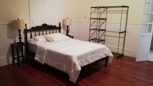 Ein Schlafzimmer mit einem Holzbett, zwei Nachttischlampen und einem Regal aus Metall.