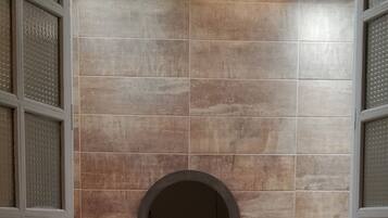 Tina con regadera, toallas, jabón, shampoo