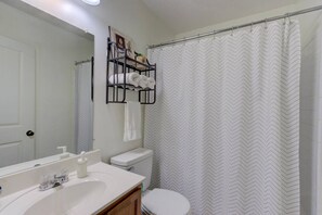 Ein Badezimmer mit Waschbecken, Toilette und Duschvorhang.