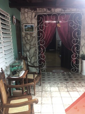 Experience tranquility in this inviting space, featuring a rustic stone wall, a wooden chair, and a glass fish tank.