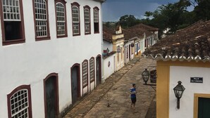 A cobblestone street lined with white buildings with arched windows and a sign reading "Rua da Câmara". - Vila Santíssima - high point of the Historic Center (Tiradentes)