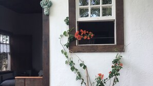 A room with a window, a potted plant, and a wooden bench. - Vila Santíssima - high point of the Historic Center (Tiradentes)