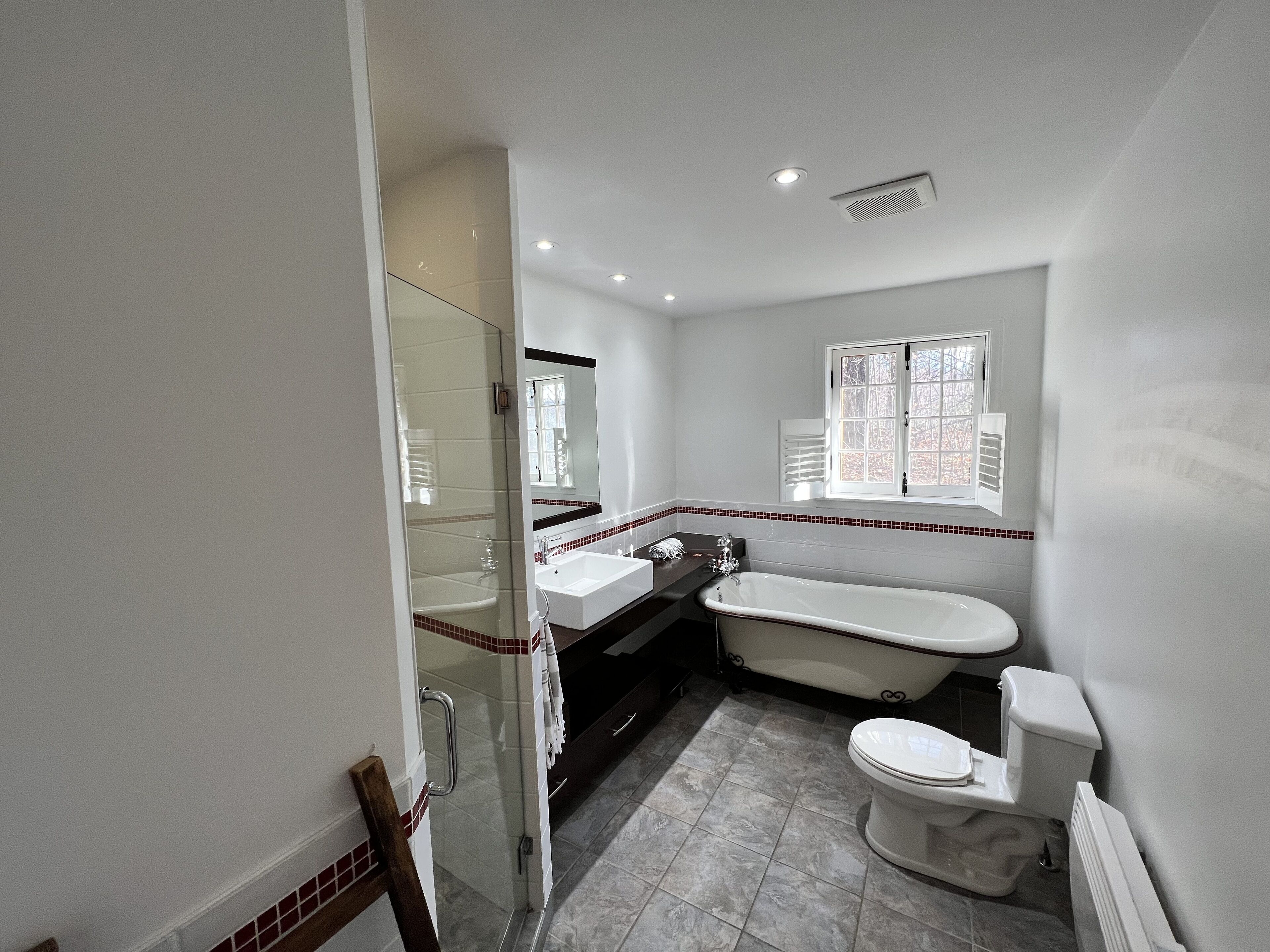 Une salle de bain avec une douche à parois de verre, une baignoire, des toilettes et un lavabo.