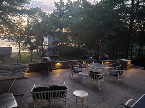 Ein Patio im Freien mit Sitzgelegenheiten und einem Grill.