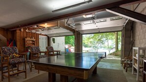 Una mesa de ping pong en una habitación con paredes de madera y una puerta de garaje.