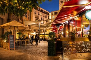 An outdoor café with tables and umbrellas, surrounded by buildings. - New Apartment in lastarria street. Fully equipped. The Best (Santiago)
