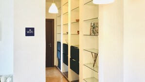 Un pasillo con paredes blancas, un letrero de WiFi y estantes con diversos objetos.