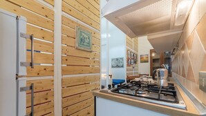 Una cocina con paneles de madera, estufa y cafetera.