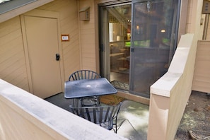 Enjoy dining or relaxing in this outdoor space with a table and chairs, connected to the interior through a sliding glass door.