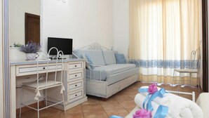 A bedroom with a bed, a desk, a chair, and a mirror. - B&B treatment in La Maddalena, Sardinia (La Maddalena)