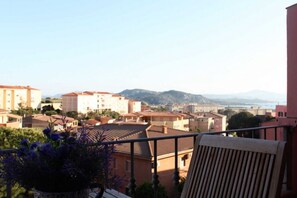 A balcony with a view of a residential area, including buildings and mountains in the distance. - B&B treatment in La Maddalena, Sardinia (La Maddalena)
