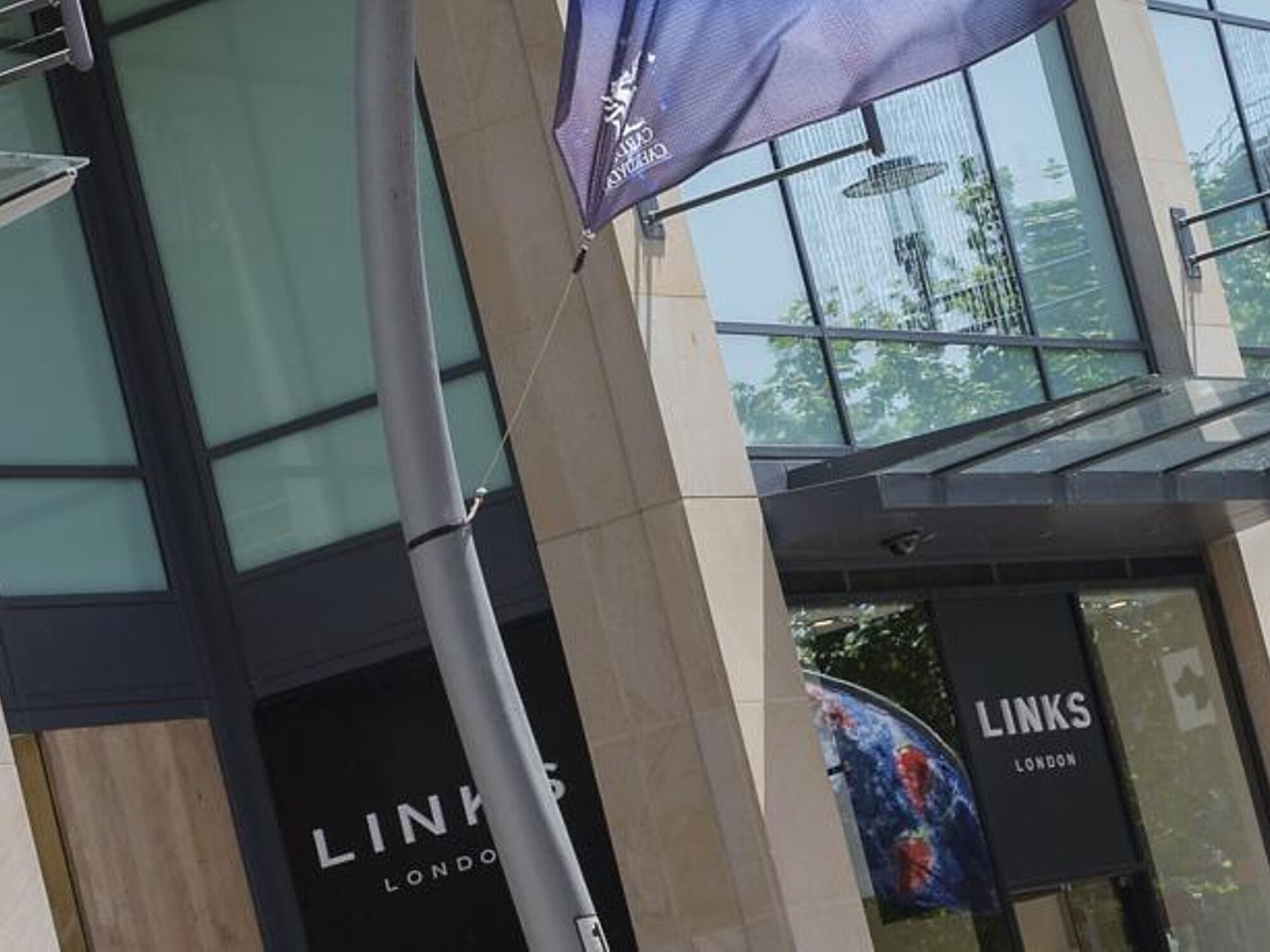 Un edificio moderno con facciata in vetro e un cartello con la scritta 'LINKS LONDON'.