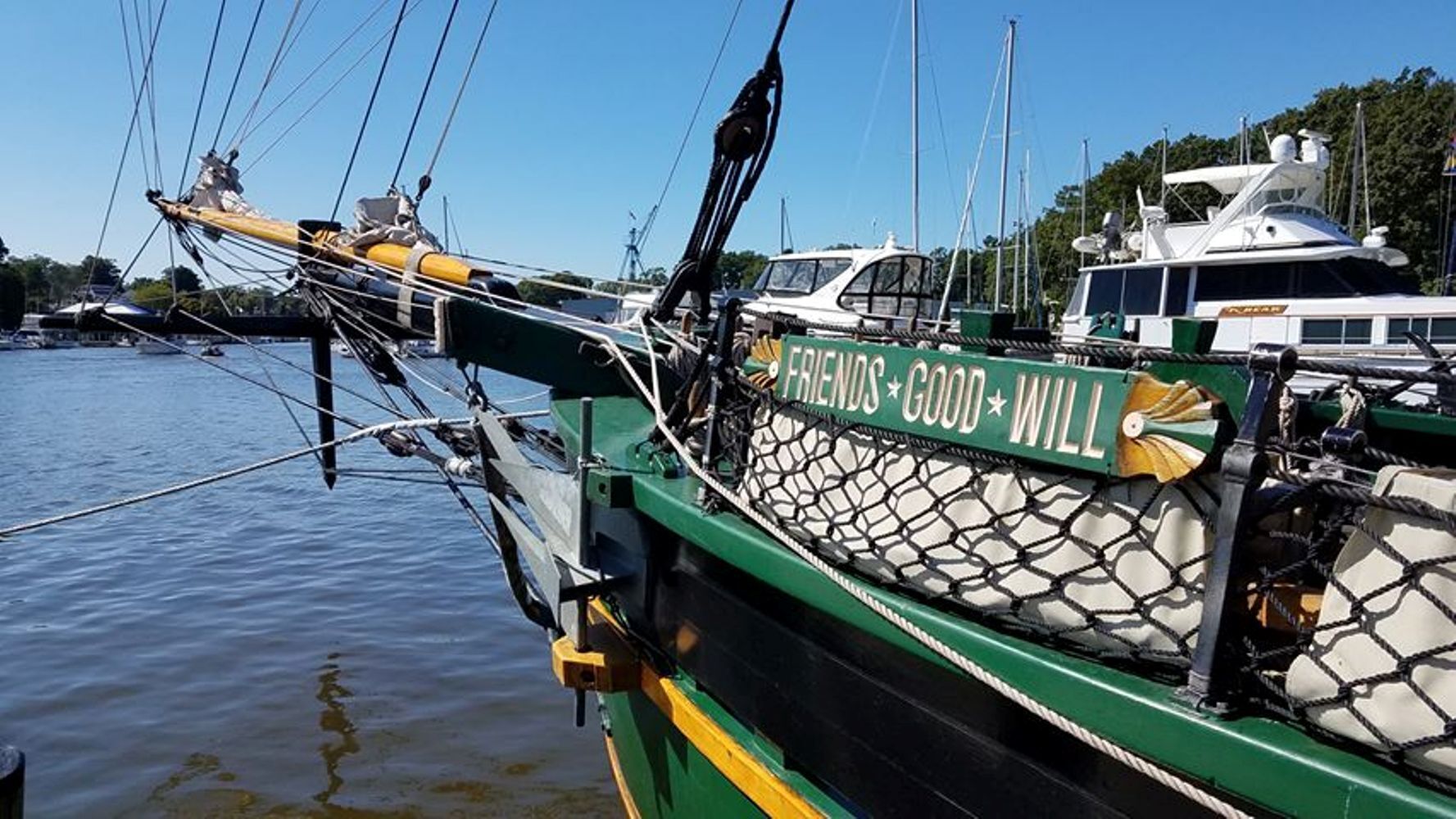 Un bateau vert avec un pont recouvert d’un filet et sur lequel on peut lire les mots « FRIENDS GOOD WILL ».