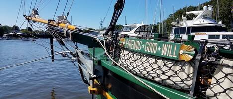 Un bateau vert avec un pont recouvert d’un filet et sur lequel on peut lire les mots « FRIENDS GOOD WILL ».