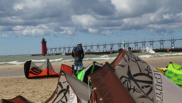 A beach with a pier, a lighthouse, and a person with a kite. - Downtown, close to everything, family friendly, newly renovated. (South Haven)