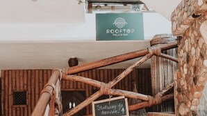 A wooden staircase with a sign reading "Stairway to heaven!" leading to a rooftop bar named Rooftop Palapa Bar.