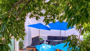 A pool area with lounge chairs, umbrellas, and a flamingo float.