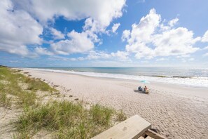 A beach with a wooden deck, grassy dunes, and a clear blue sky. - Oceanfront Corner 2BR Condo 4th Floor Amazing Ocean Views Unit 401 (Indian Harbour Beach)